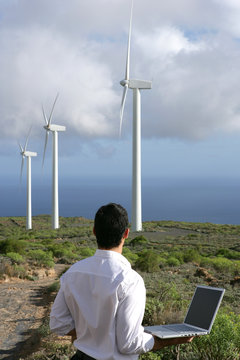 Man With Computer Watching Wind Turbines