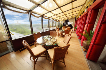 Beautiful wicker chairs and glass tables in restaurant