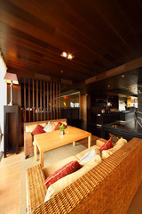 Wicker couches with pillows and table in empty restaurant