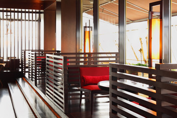 Row of brown tables and red seats in empty cozy restaurant