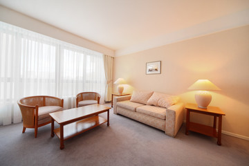 Simple light comfortable room in hotel; soft sofa and big window