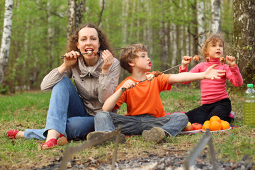 Fototapeta premium Mother and children finish to eat grilled shish kebab