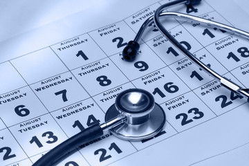 A stethoscope lying on a calendar