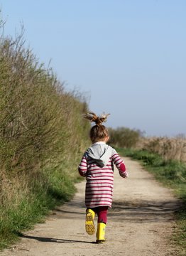 petite fille courant sur un sentier de randonn&eacute;e