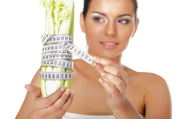 oung woman with vegetables and measuring tape