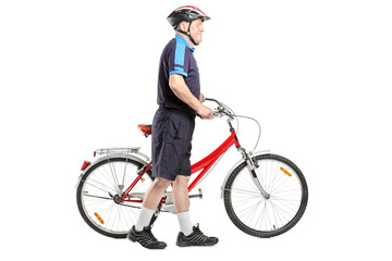 Obraz premium Full length portrait of a senior bicyclist pushing a bicycle