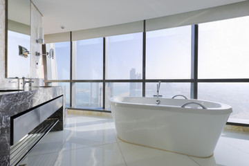Luxury bathroom with stand alone tub near windows in a skyscrape