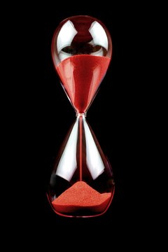 Hourglass With Red Sand On Black Background
