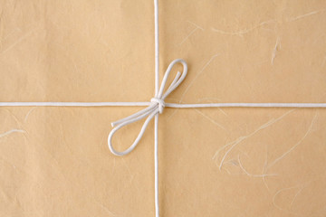 A bow from a string on a brown packing paper