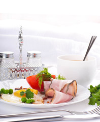 Bacon with fried eggs and tomatoes, a peas and corn