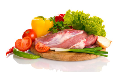 Raw meat and vegetables on a wooden board isolated on whitе