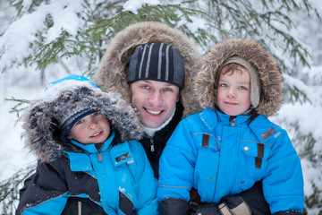 Father and two sons in  winter forest