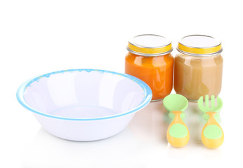 Jars of baby puree with plate, spoon and fork isolated on white