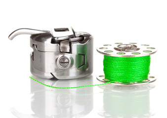 Metal spool of thread and sewing machine shuttle isolated