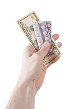 Money and pills in hand isolated on white
