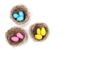 Colorful easter eggs in nests isolated on white