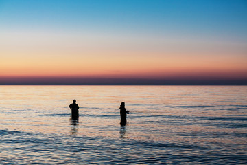 Angler im Sonnenuntergang an der Ostseeküste.