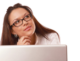 A young woman wearing glasses in front of a laptop