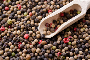 Pile of mixed peppercorns with a spice scoop