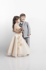 Two beautiful little boys and girls in wedding dresses