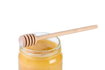 Jar with honey and wooden stick.