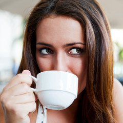 Closeup portrait of a pretty young female having a cup of coffee