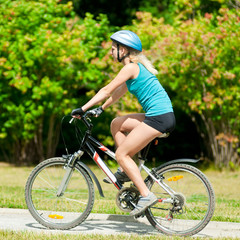 Obraz premium Young smiling woman on bike