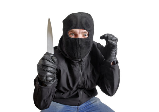 Masked criminal holding a knife, isolated on white