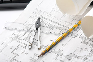 Compasses, a pencil  and a ruler over a draft