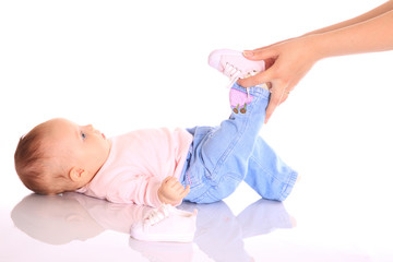 mother putting shoes on baby