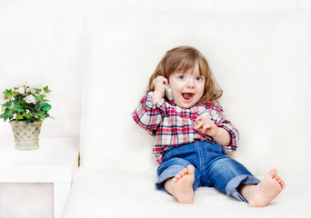 beautiful little child holds a cell phone