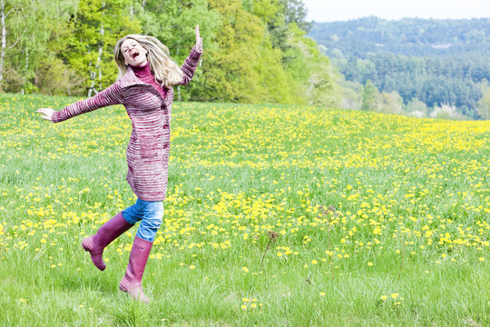 Woman Wearing Rubber Boots On Spring Meadow