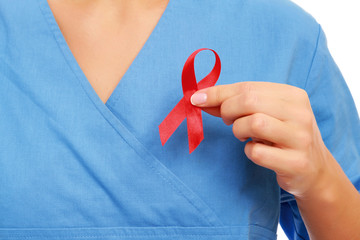 Close-up of hand holding an aids red ribbon