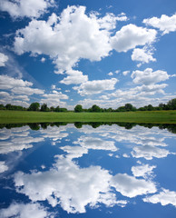 Fototapeta na wymiar Calm beautiful rural landscape with a lake and sky reflected