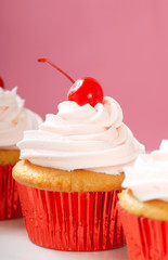 Vanilla cupcake with maraschino frosting and cherry