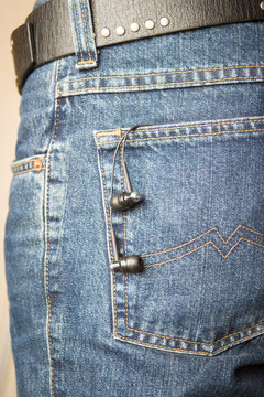 Ear phones hanging out of pocket