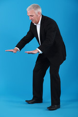A mature businessman gesturing.