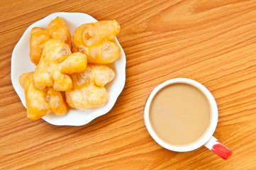 fried dough and coffee on wood background
