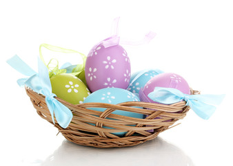 Colorful easter eggs in basket isolated on white
