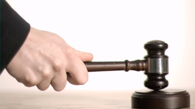 Gavel in slow motion hitting a sound block