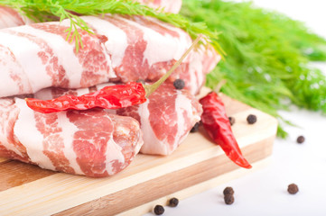 Meat rolls with fennel and red pepper on a bamboo board