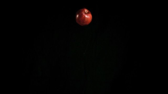 Red apple falling in super slow motion