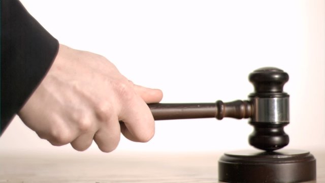 Brown gavel in super slow motion hitting a sound block