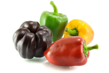 Red, green and violet sweet pepper on a white background