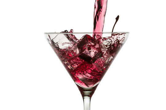 Ice cubes and red liqueur in a glass of martini on white backgro