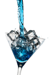 Blue drink poured into a glass with ice cubes