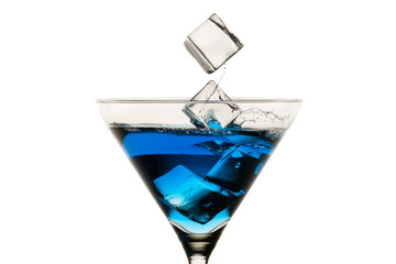 Dropping ice cubes into martini glasses on white background