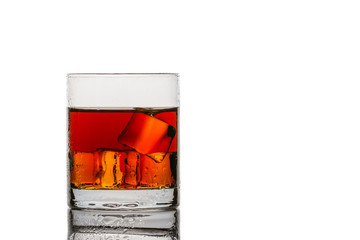 Glass with ice cubes and whisky on white background
