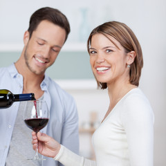 mann schenkt seiner freundin wein ein