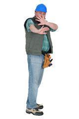 Builder shielding his face in fear